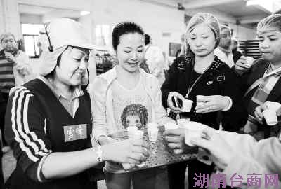 林君盈(左)和游人一起品尝刚刚生产出来的茶叶。